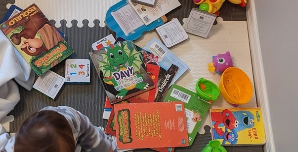 Vários livros infantis espalhados pelo chão"