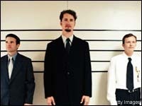 Homem alto de terno alinhado com outros mais baixos