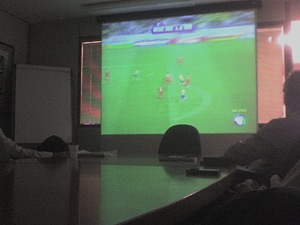 Jogo de futebol no datashow da sala da reunião
